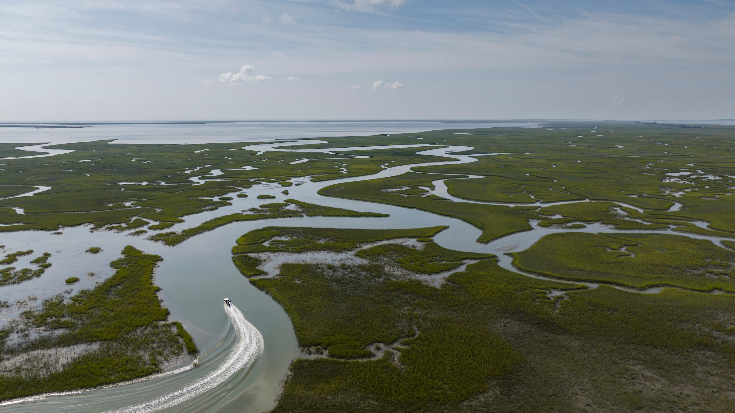 A boat drives through bending areas of water on the Eastern Shore of Virginia. 