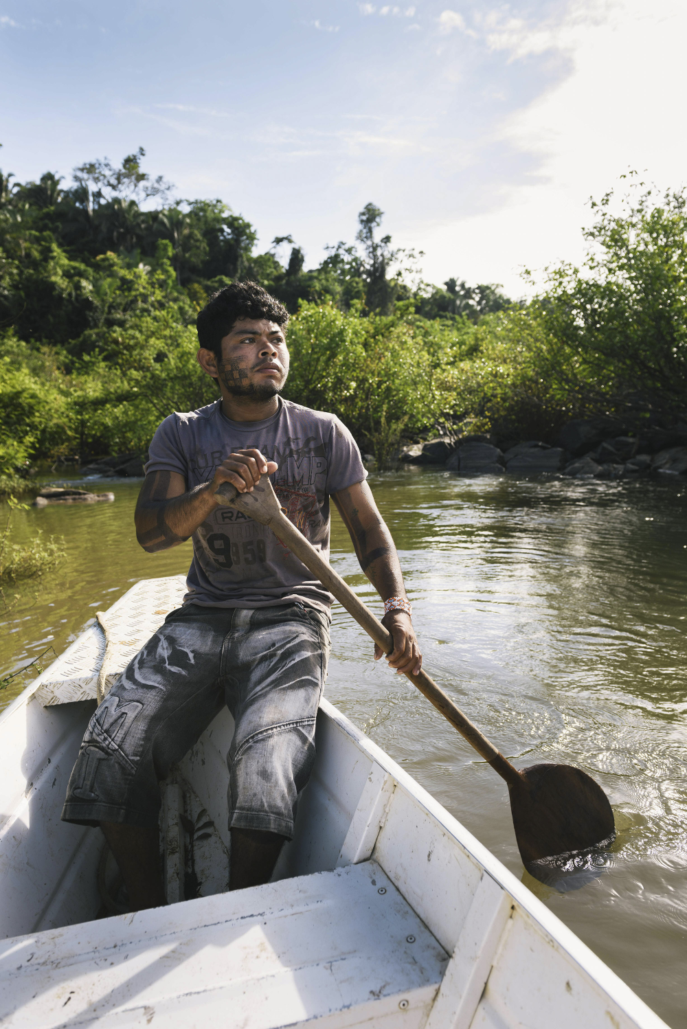 A man paddles a small boat on the Amazon river.