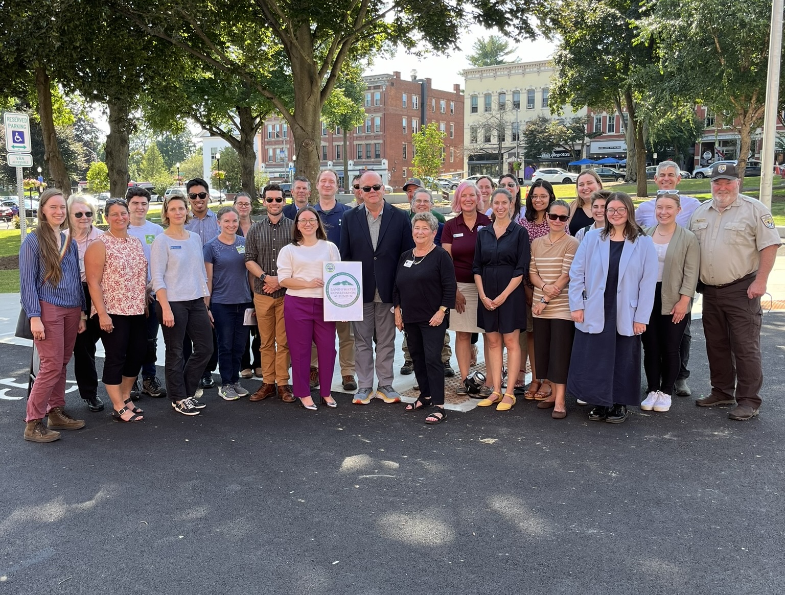 A group of about 30 people pose on Amherst Town Common while celebrating the 60th Anniversary of LWCF.