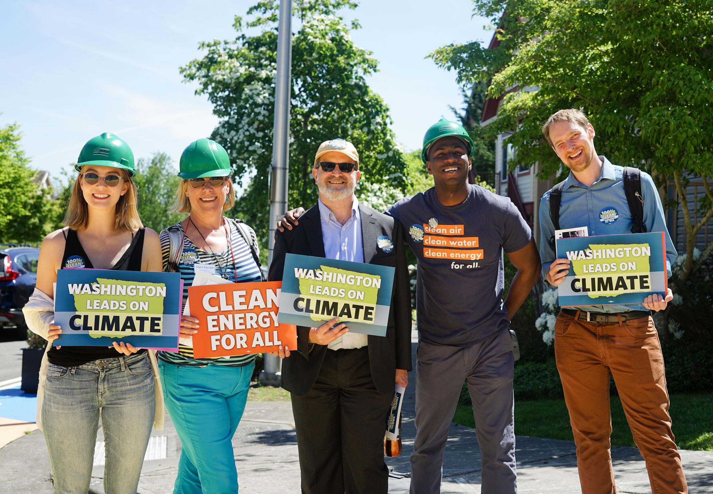 people in hard hats holding signs that say "washington leads on climate".