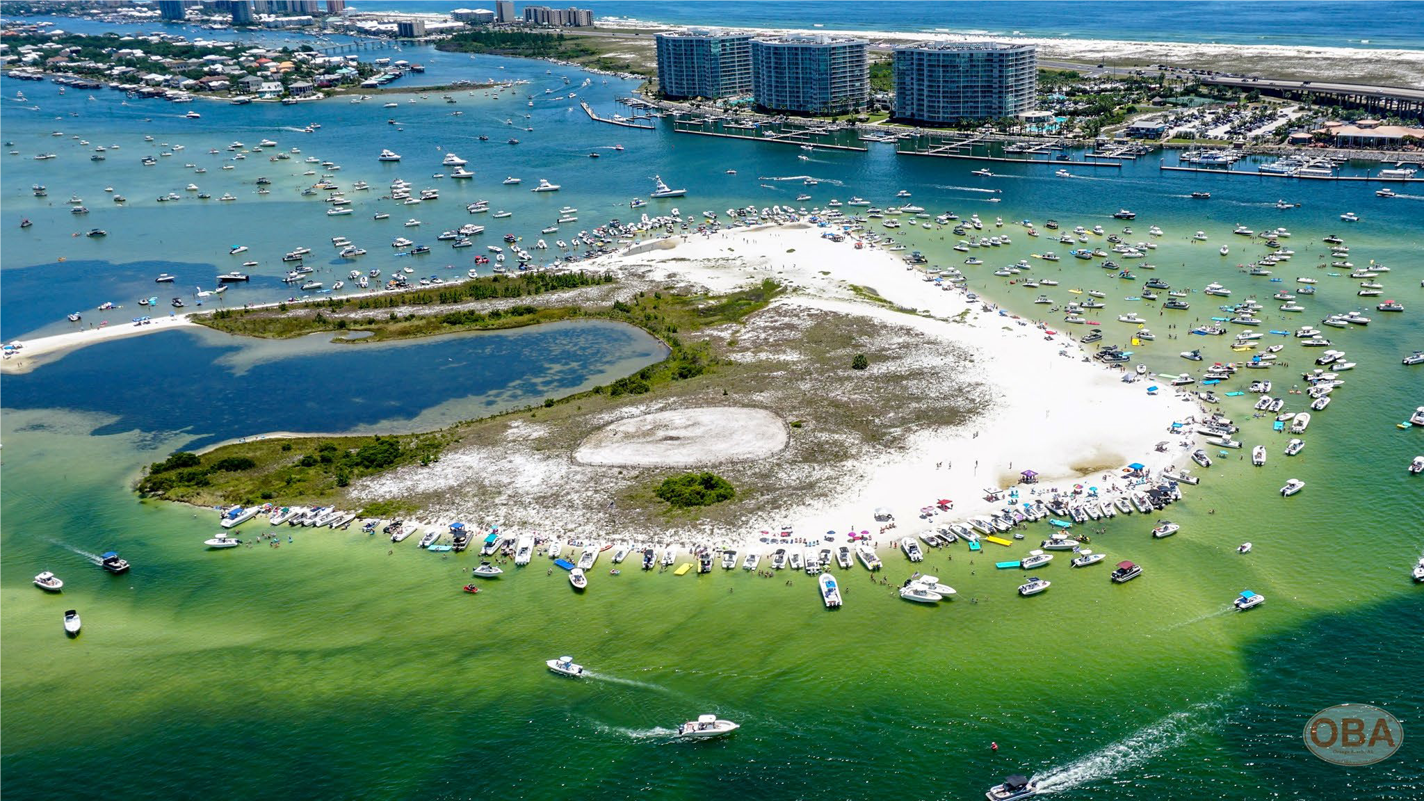 Blue waters surround a sandy island.