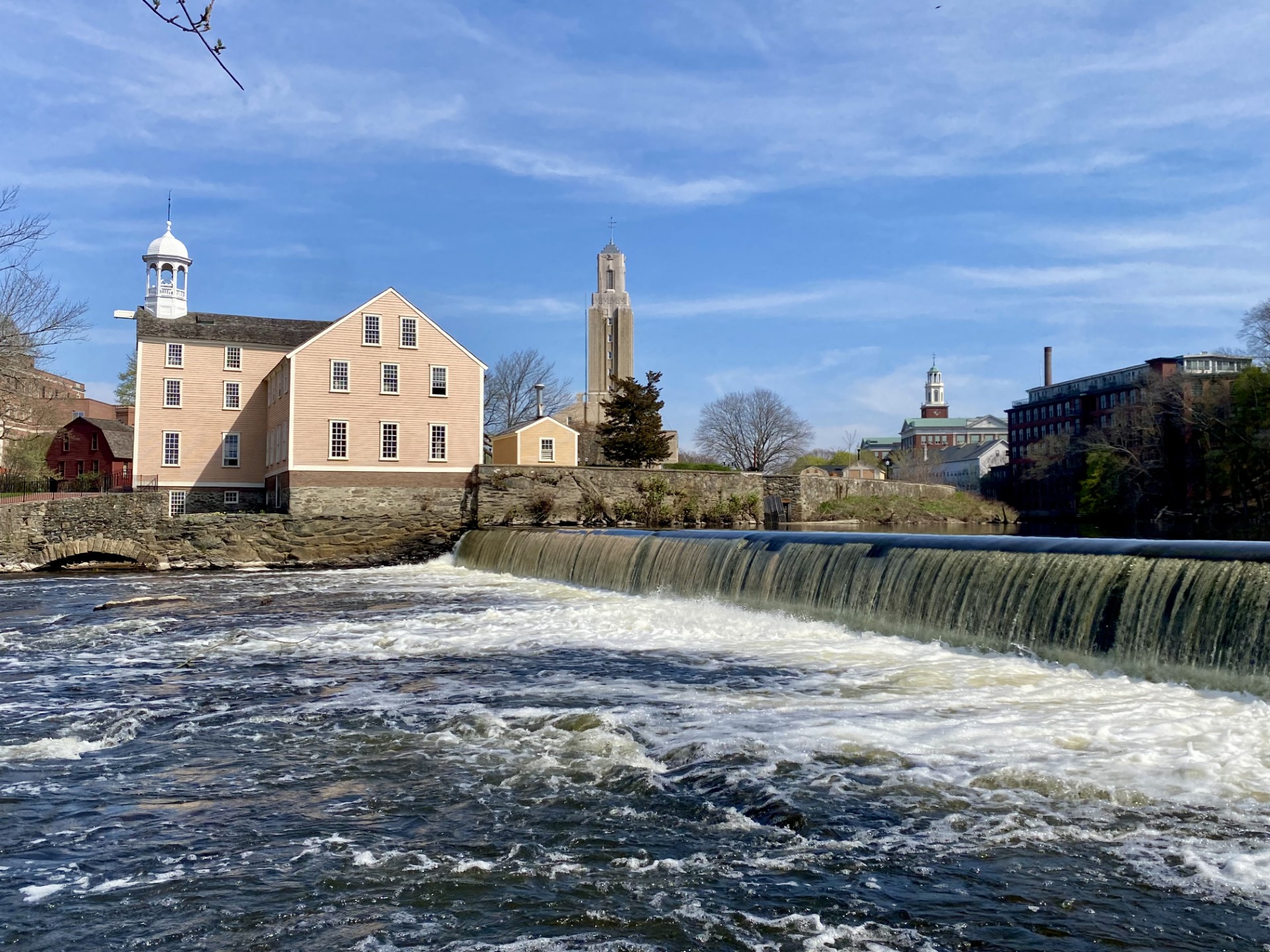 A dam spans a river with buildings beyond.