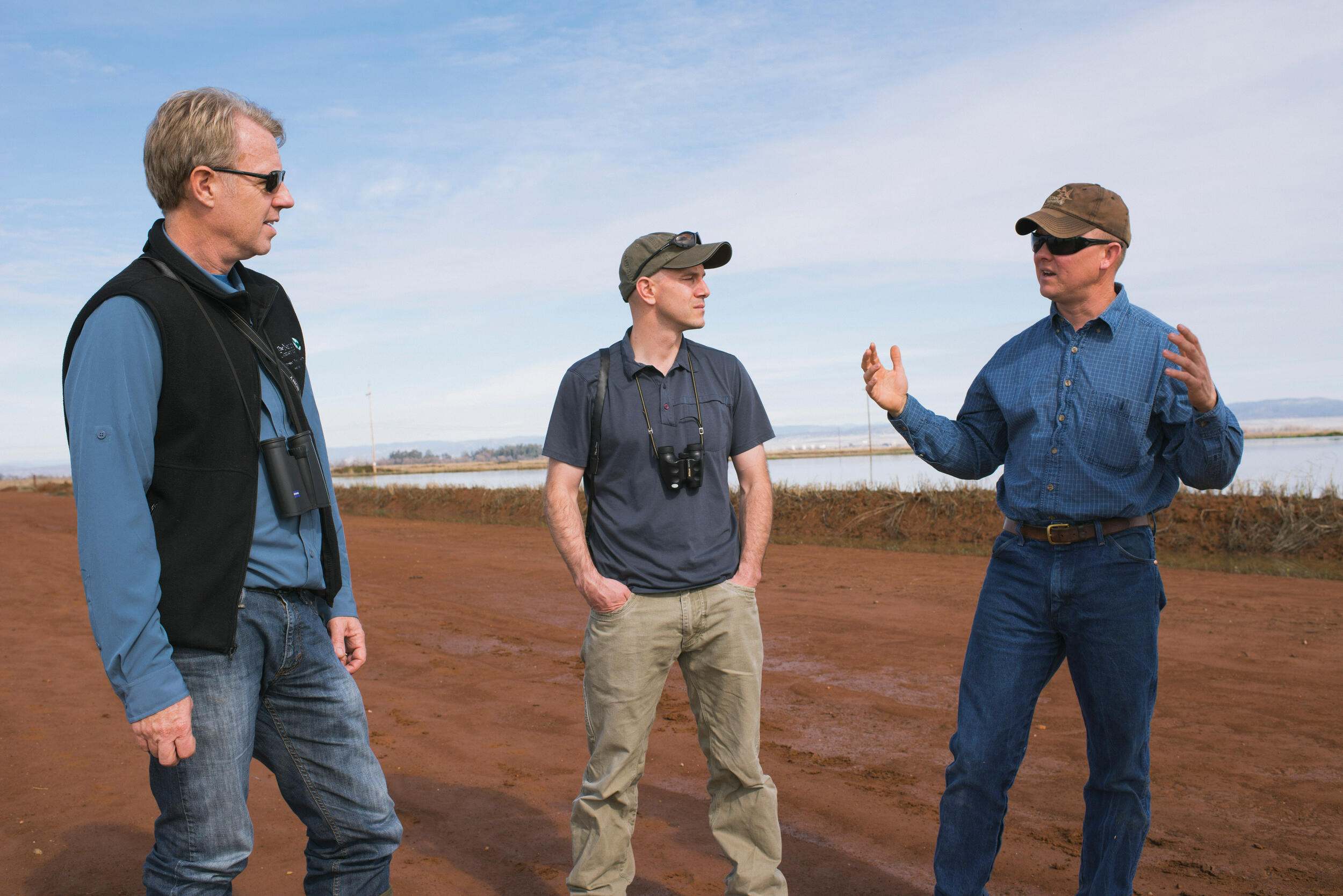 Farmer Doug Thomas talks with Mark Reynolds and Eric Hallstein, economist and designer of Reverse Auction, in rice fields near Olivehurst, California.  