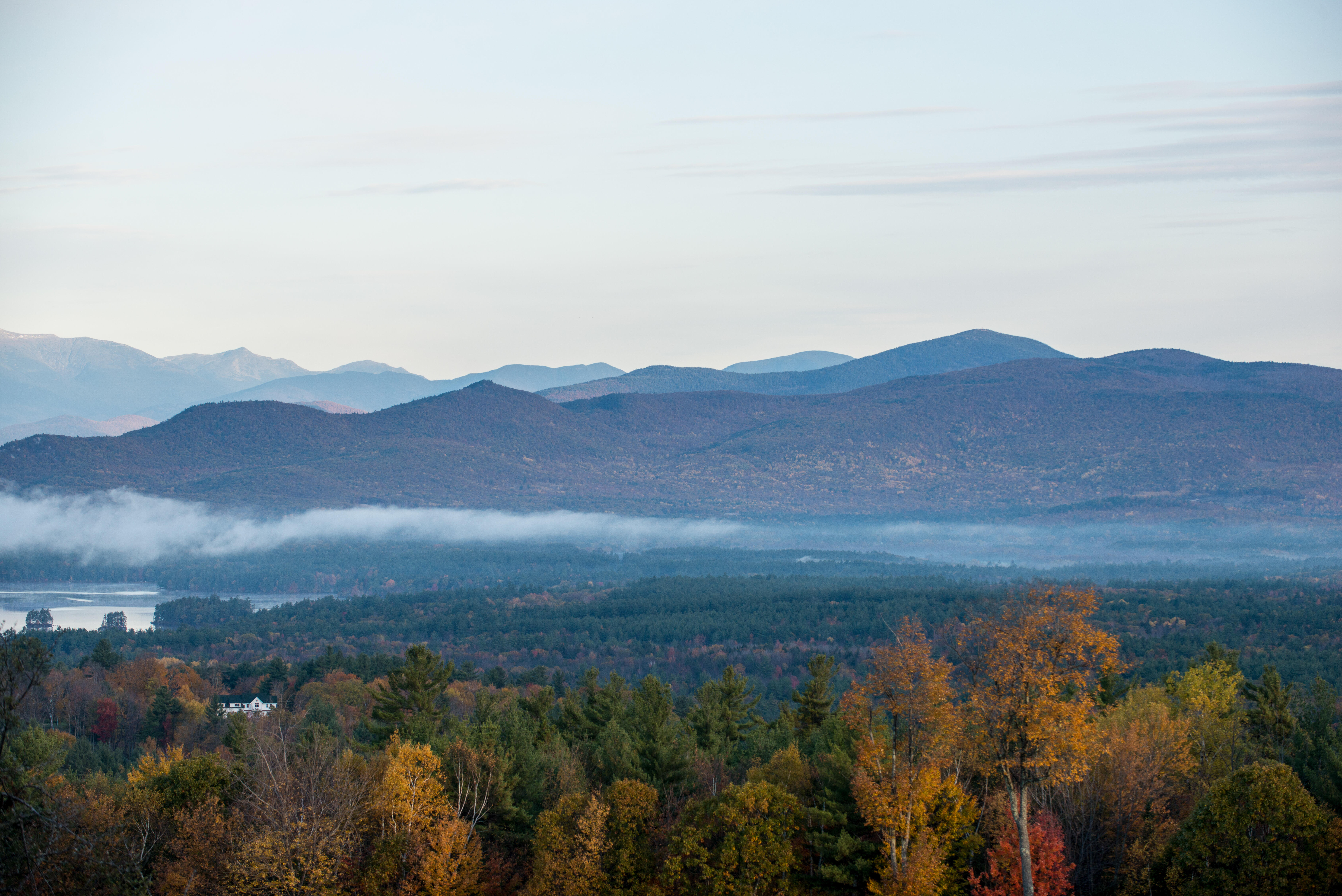 Thin clouds frame mountains and a forested valley.