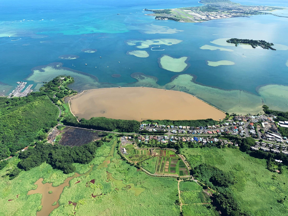 Aerial view of a muddy brown fishpond.