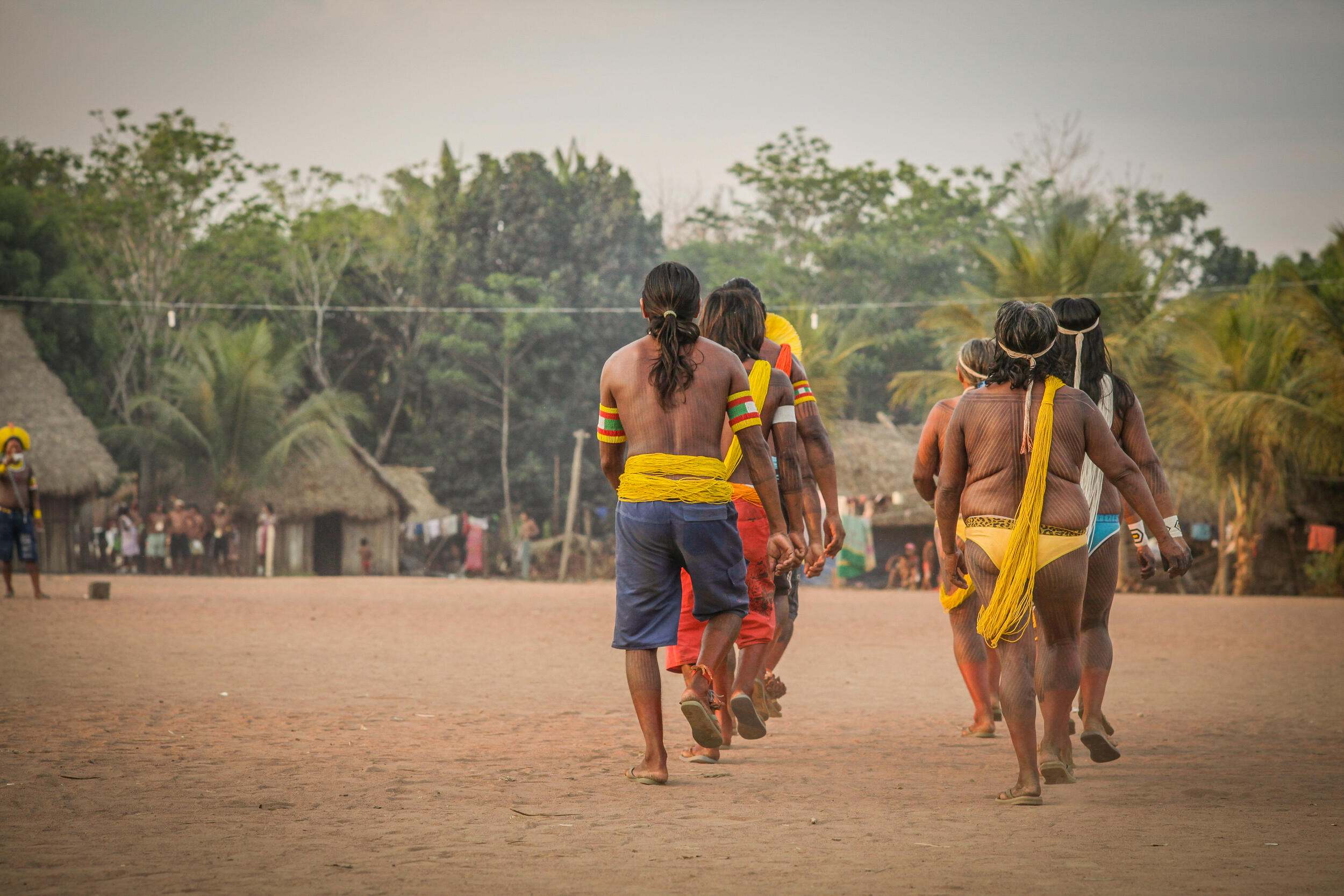 A group of Indigenous men walks away from the camera.