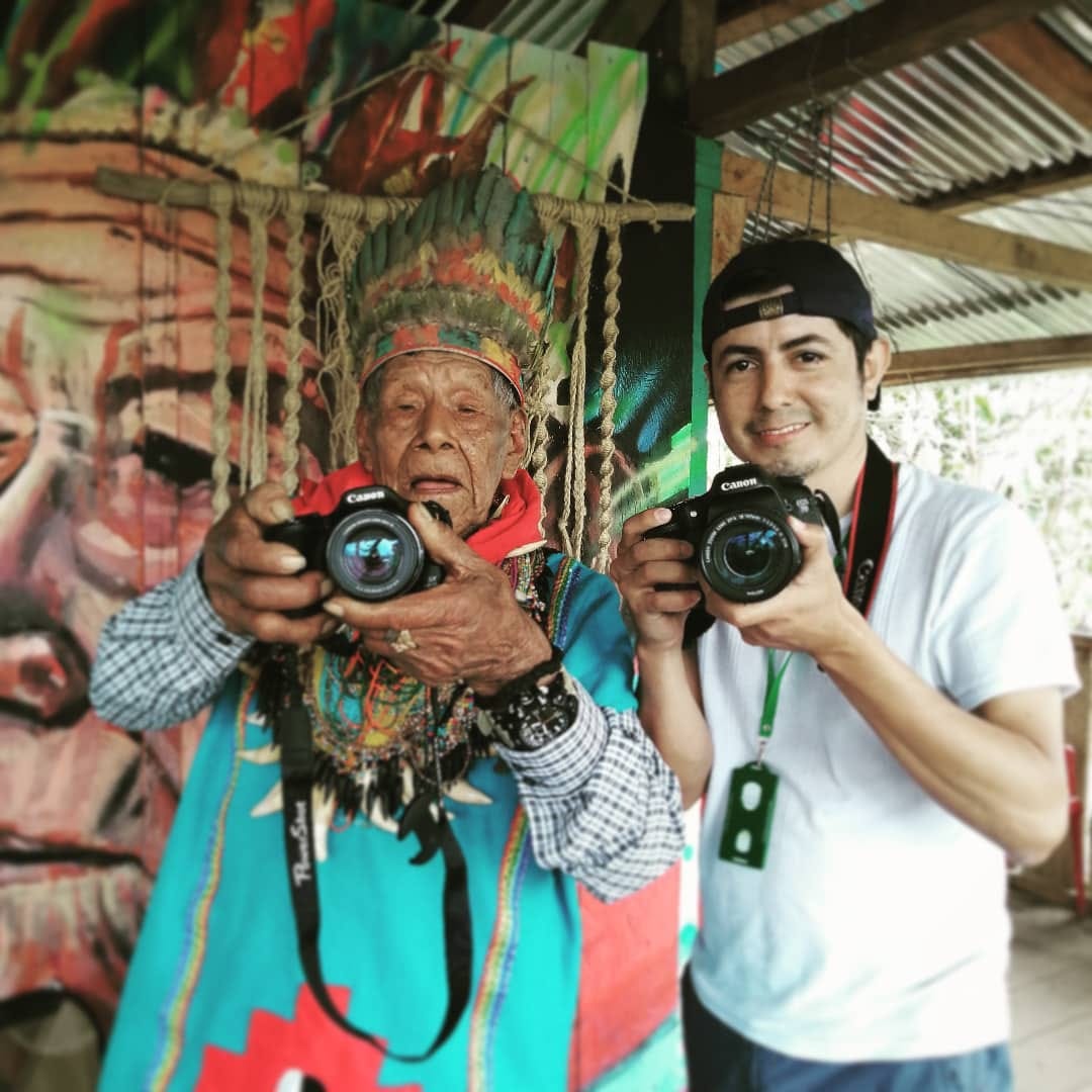 Portrait of Duber Rosero with and indigenous elder, both holding a camera.