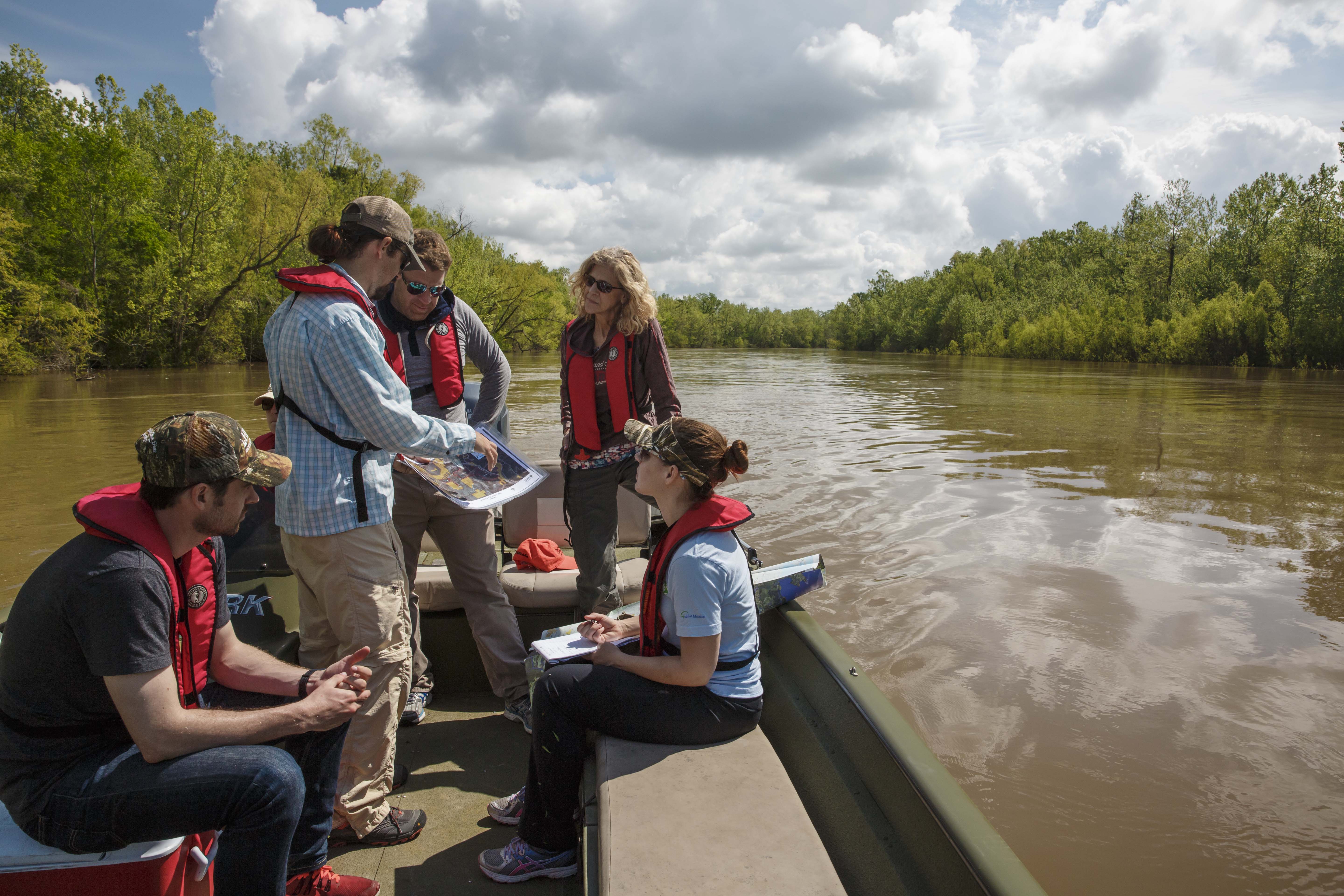 A group of people on a boat in the Atchafalaya River Basin.