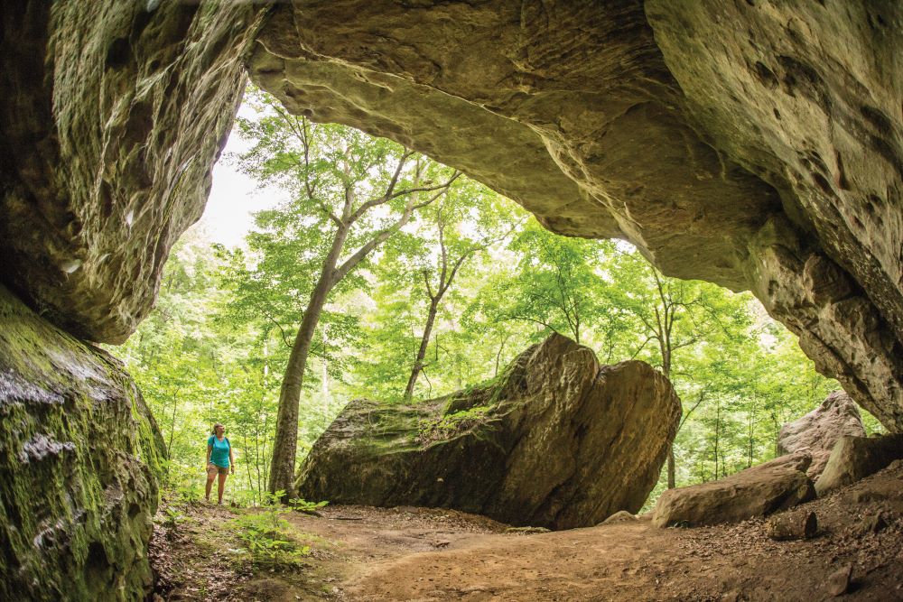 Person looking into a cave.