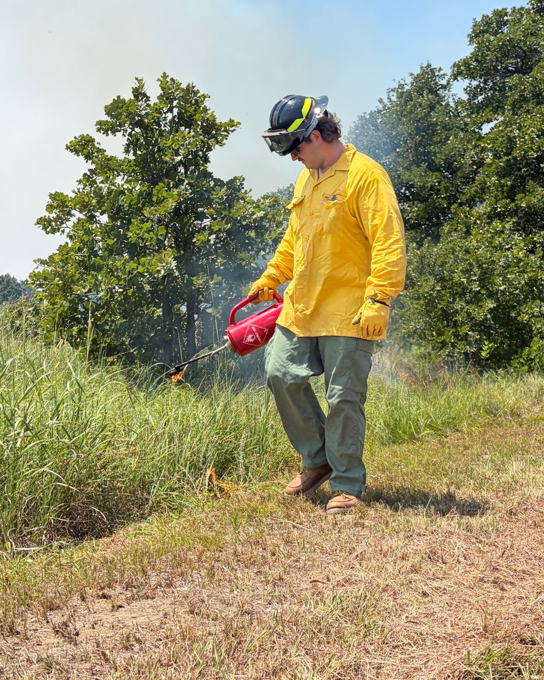 A person using a drip torch to assist with the prescribed burn at Pearl Jackson Crosstimbers Preserve.