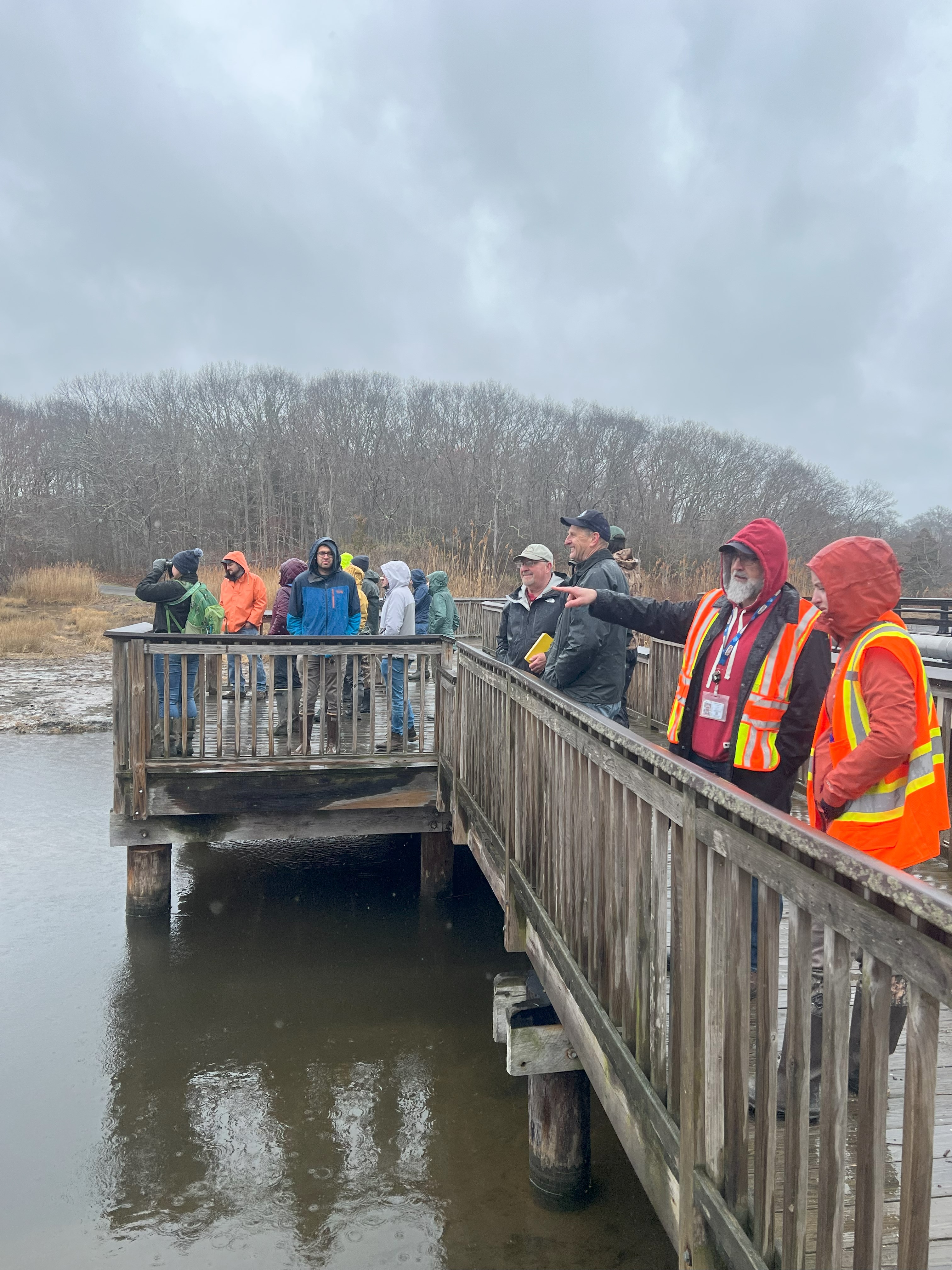 group of people with bright vests on a bridge.