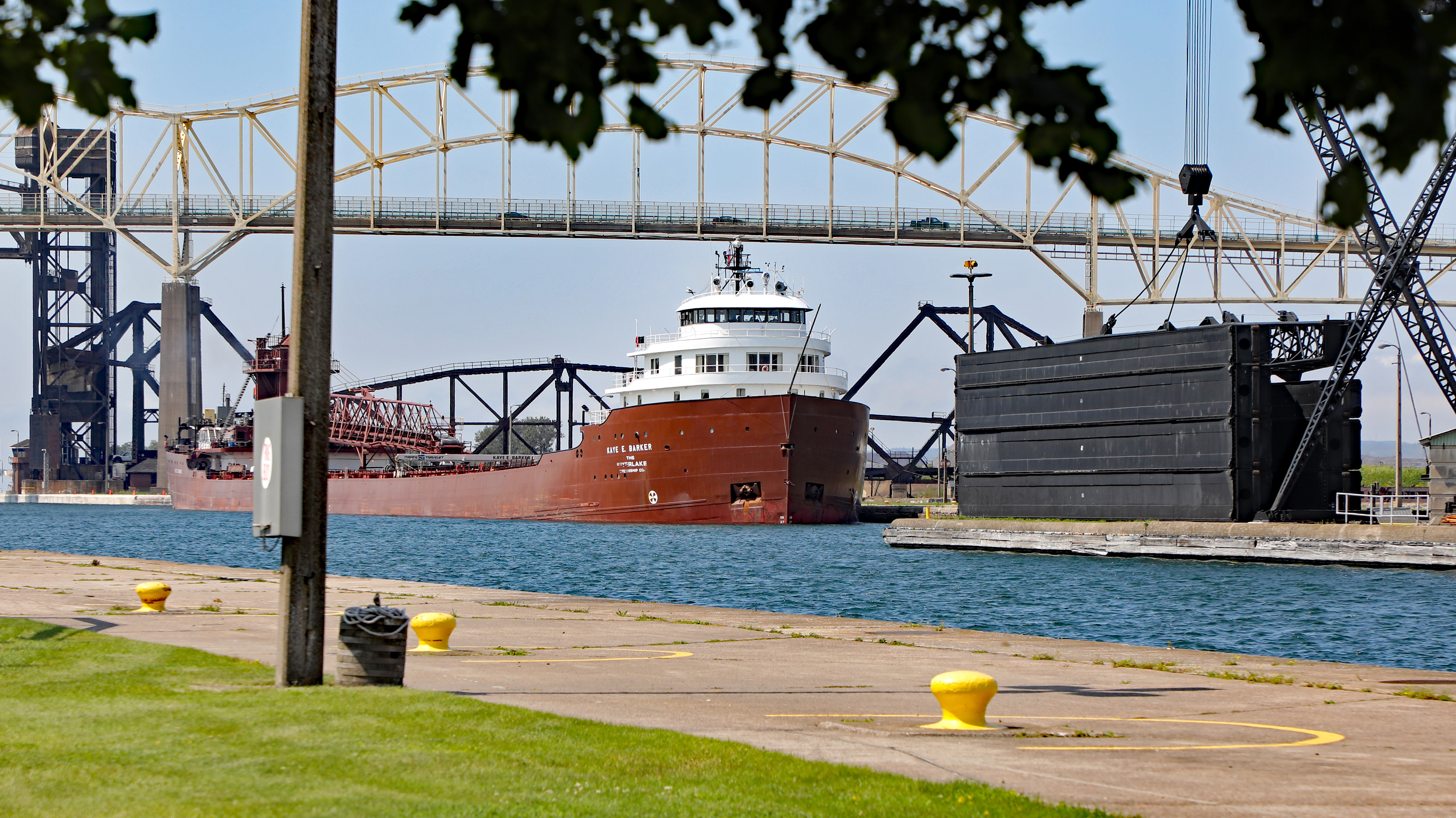 A large ship floats in a lock system near a dock.