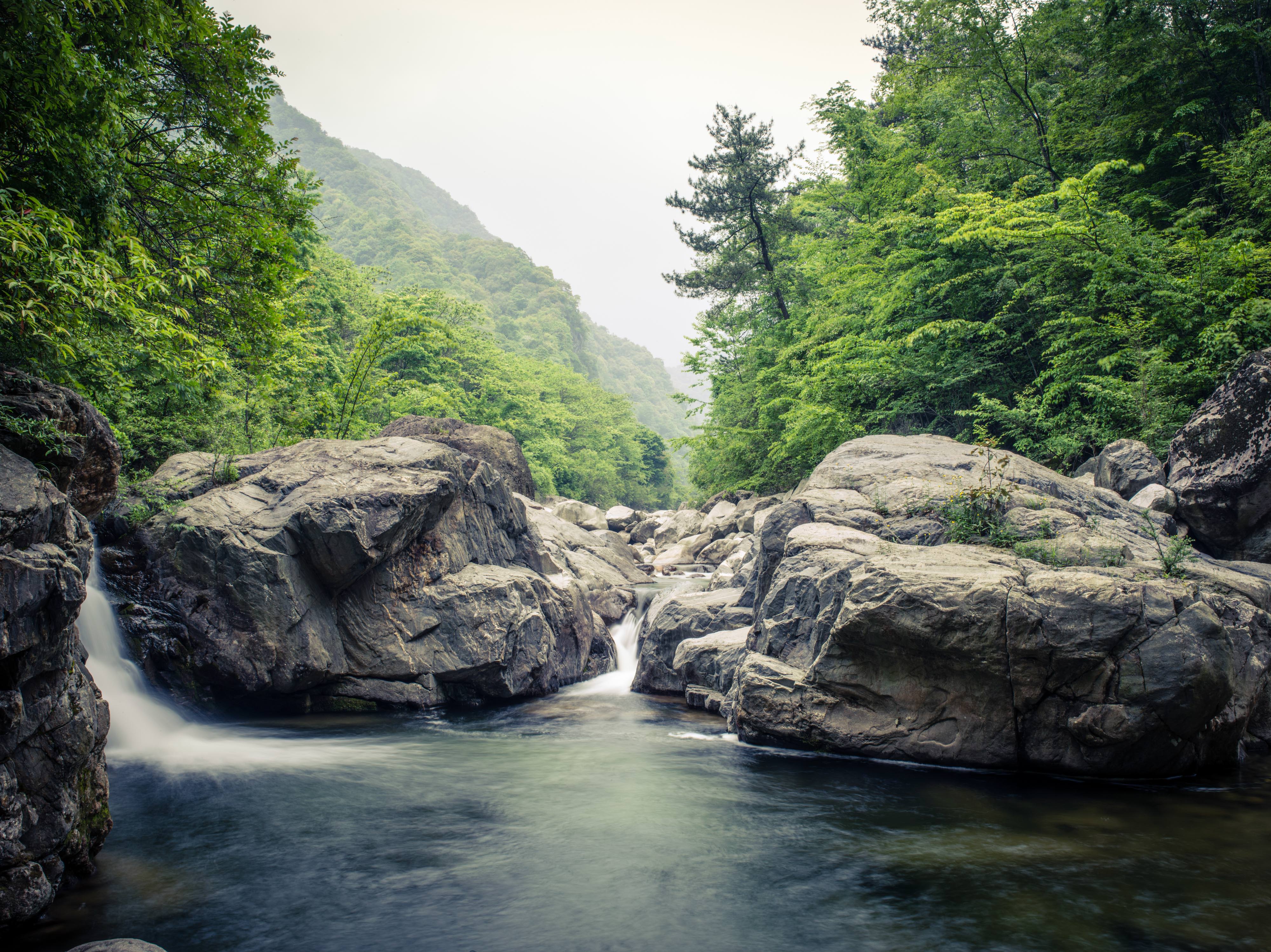 Water from Old Creek River flows past giant boulders.