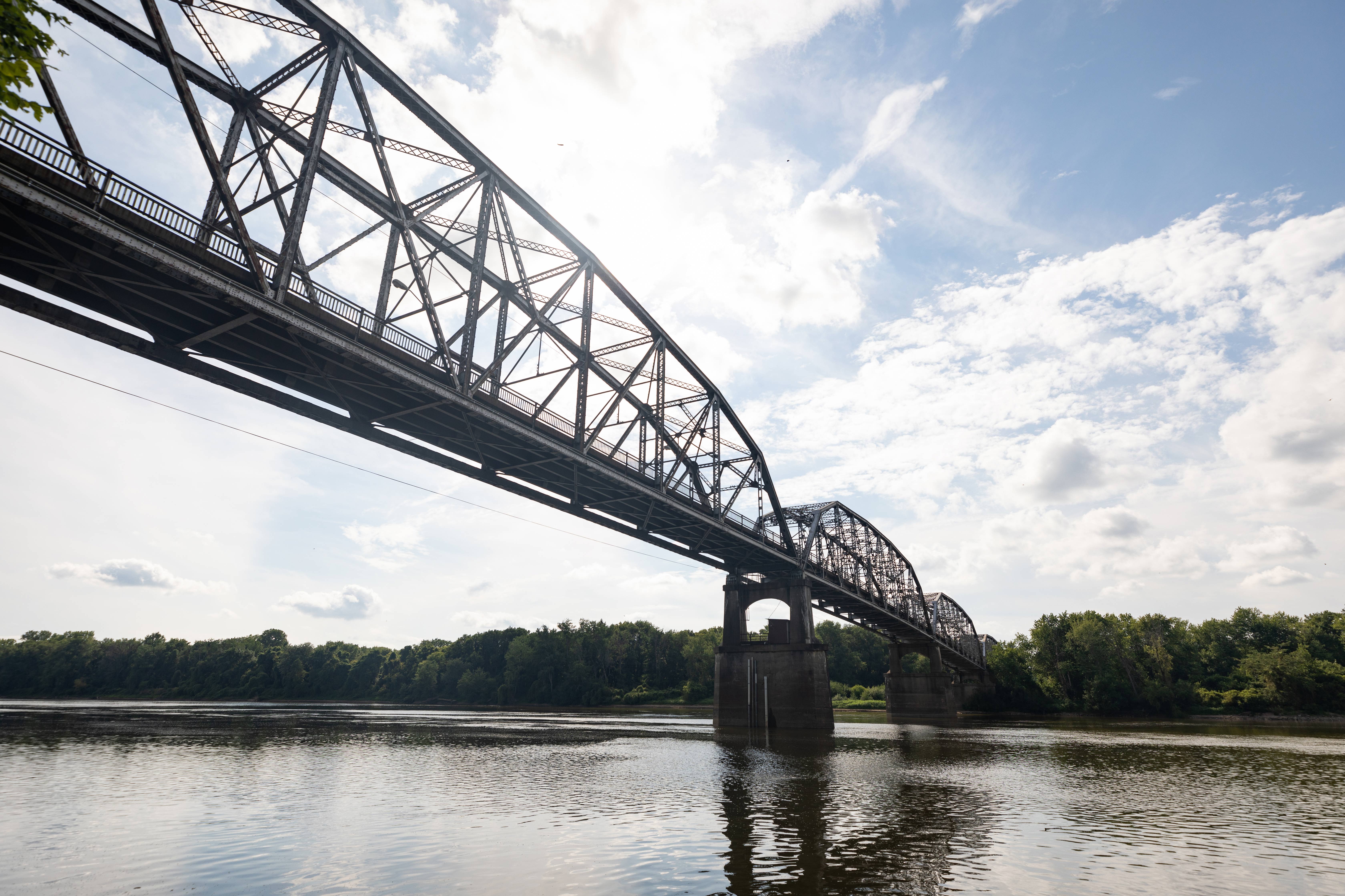 Bridge over a river beneath blue skies.