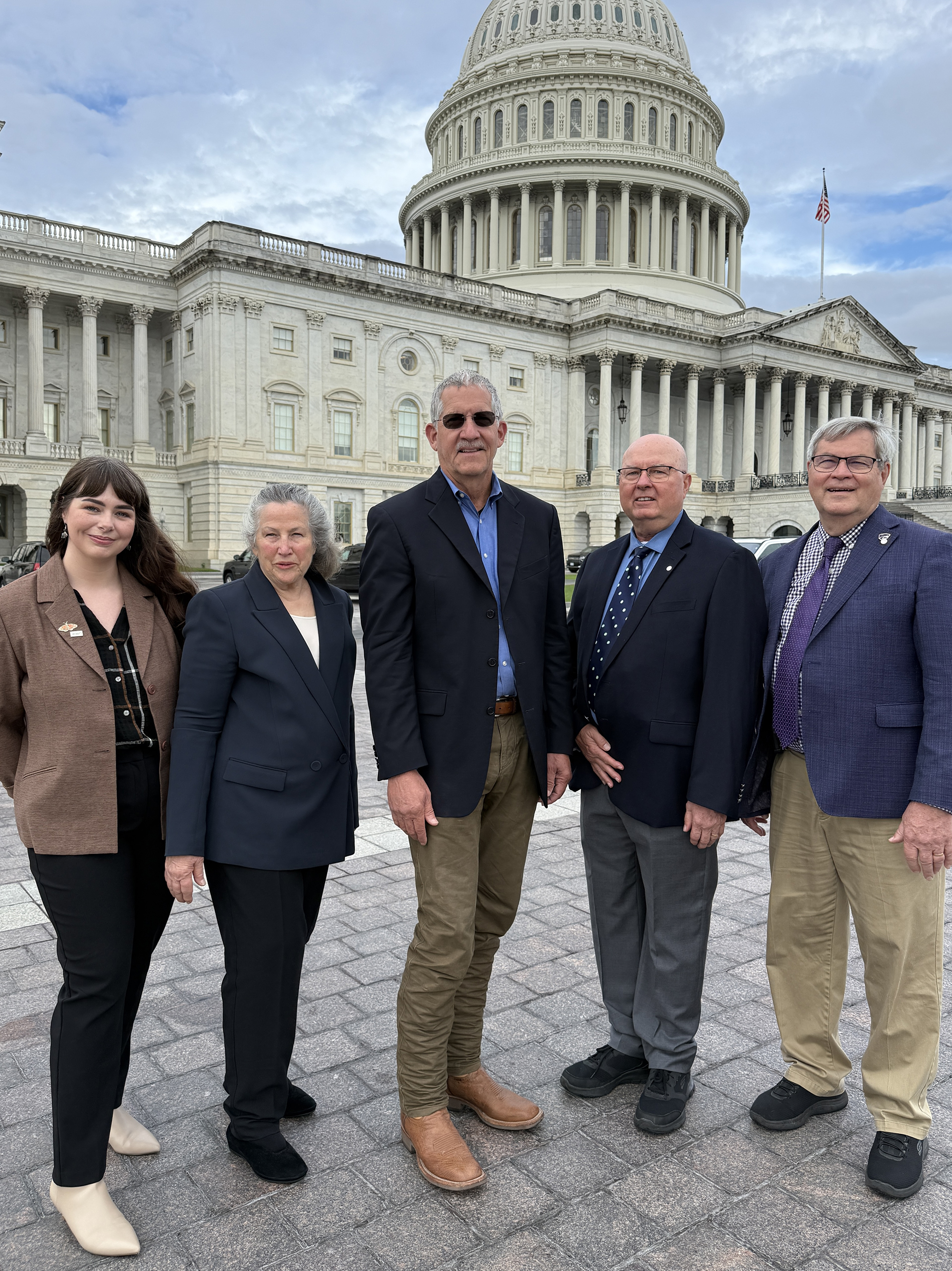 Five adults stand in front of the U.S. Capitol in Washington D.C.