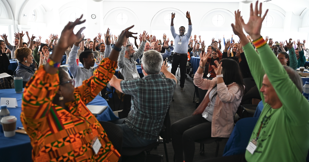 People with their hands raised in a crowd.